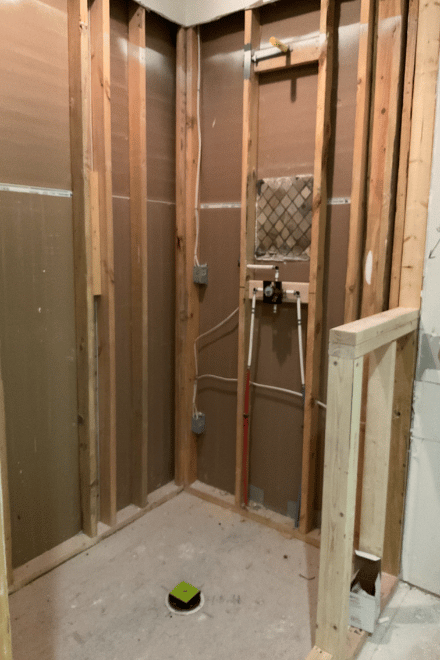 A bathroom after initial demolition, showing framing in walls