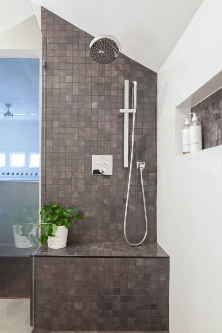 A beautifully tiled shower with a seating area created by Ranney Blair