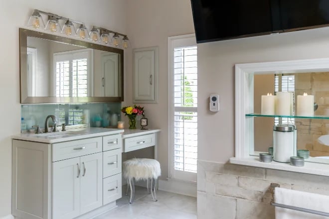 A large framed vanity mirror next to a natural light source