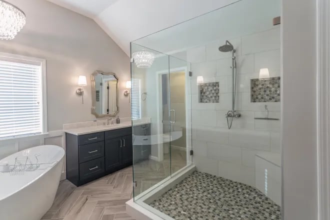 A luxury bathroom with a glass shower enclosure created by Ranney Blair