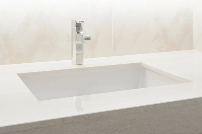 An ultra compact quartz countertop provides unparalleled durability in this bathroom