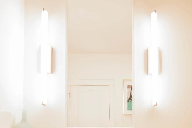 Stylish lighting fixtures on either side of a mirror