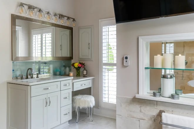 A bathroom with a vanity cabinet and open shelving built in to the wall