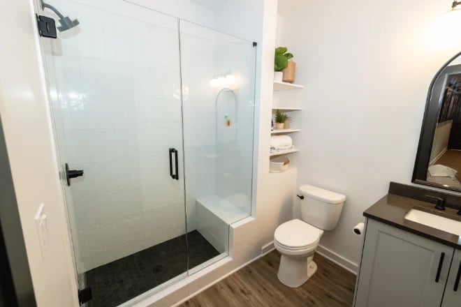 A bathroom with open shelving by the toilet