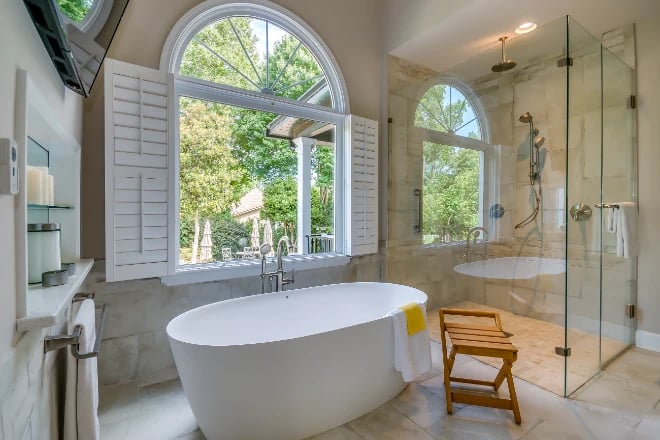 A beautifully remodeled bathroom with wooden shutters
