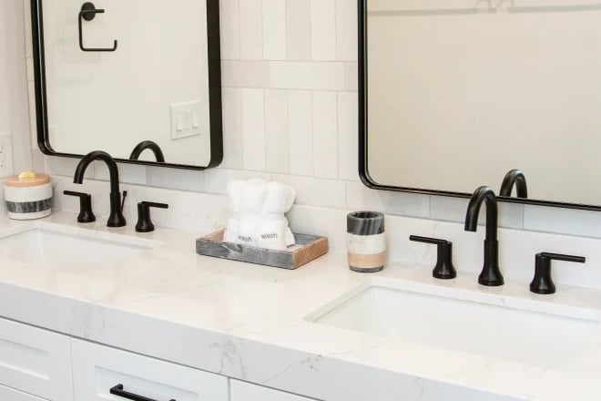A double-sink vanity with two deck-mounted faucets in a bathroom remodeled by Ranney Blair