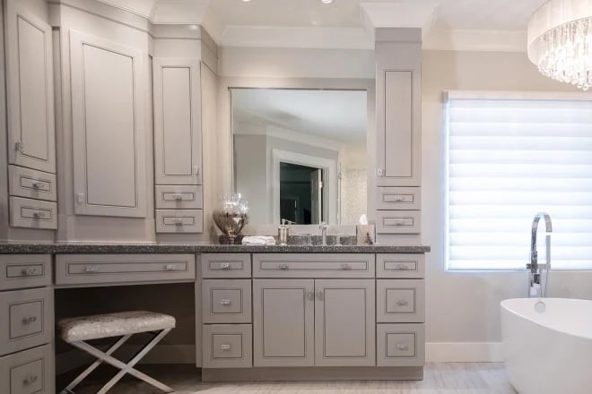 A frameless mirror above a vanity in a luxury bathroom