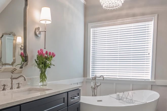 A gorgeous bathroom with blinds as a window treatment