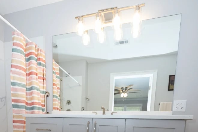 A large frameless mirror in a shared bathroom
