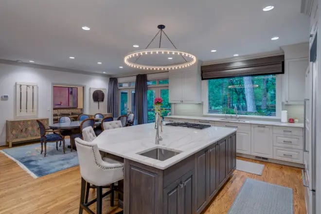 A light-colored wood floor adds elegance to this kitchen remodel by Ranney Blair Weidmann