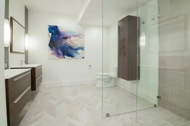 A luxury bathroom crafted by Ranney Blair Remodeling with a frameless shower enclosure