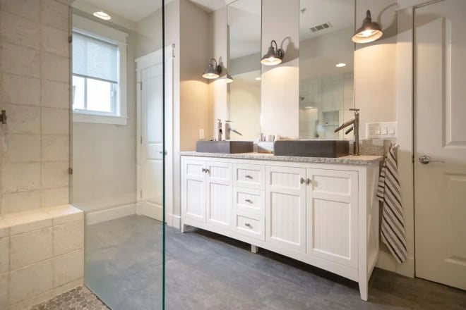 A remodeled bathroom with two beautiful mirrors above a vanity