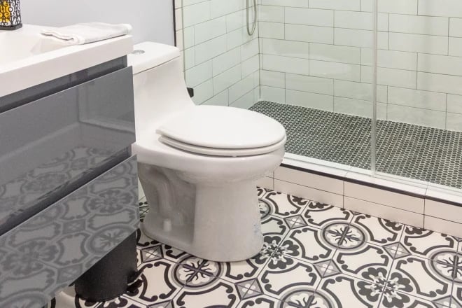 An eco-friendly toilet in a bathroom with graphic floor tiles
