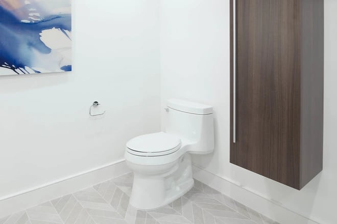 An eco-friendly toilet in a contemporary bathroom with modern art on the wall