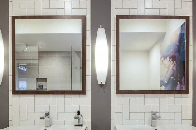 Two vanity mirrors with wood frames in a contemporary bathroom design