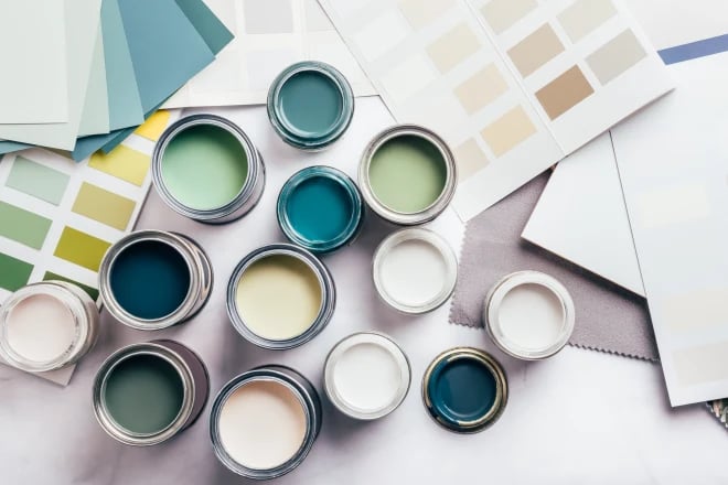 Various cans of paint with beige and green colors visible and color samples