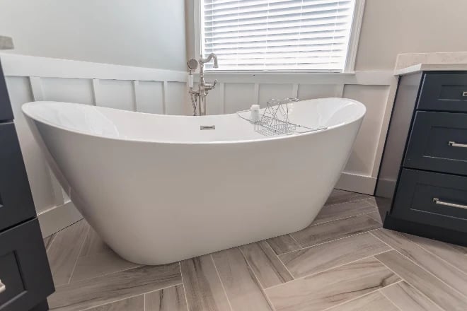 a freestanding tub with blinds in the background