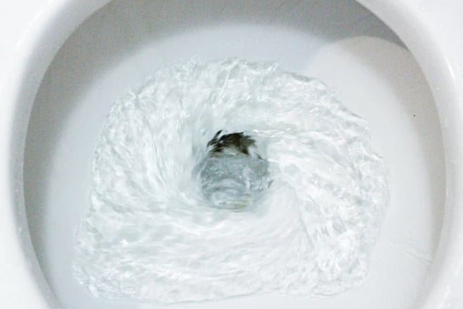 close up flushing toilet bowl 