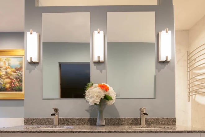 two frameless mirrors with three lighting scones