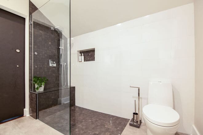 A bathroom design that contrasts dark and light colored tile.