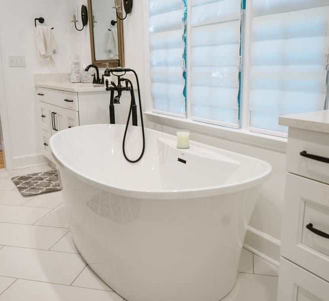 A white bathroom with large floor tiles.