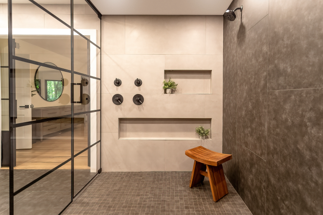 A large shower room with a small wooden bench