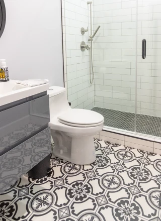 Standard height toilet in bathroom with black and white tilework