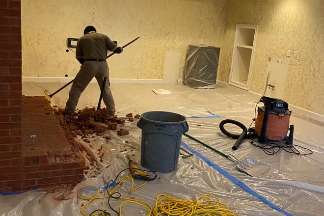A Ranney Blair Remodeling employee sweeping debris for a basement remodeling project