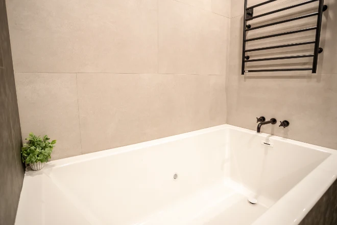 A bathtub surrounded by quartz tiles