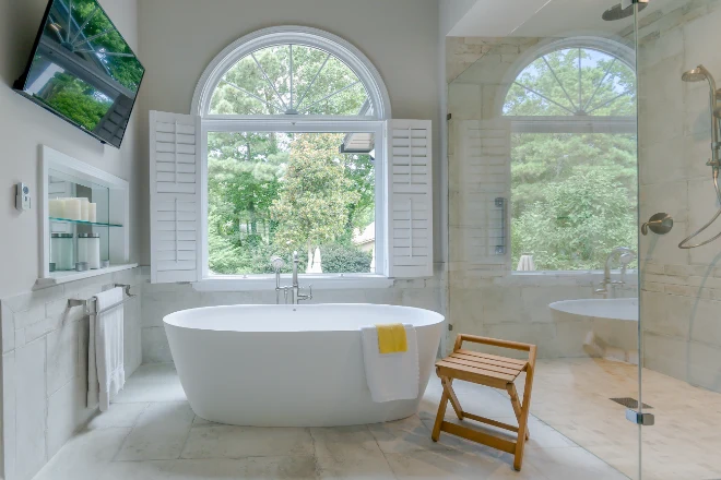 A beautiful freestanding tub with a yellow towel draped on it