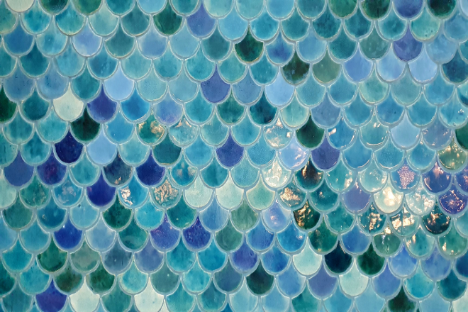 A close up of beautiful blue scalloped tiles on a bathroom wall