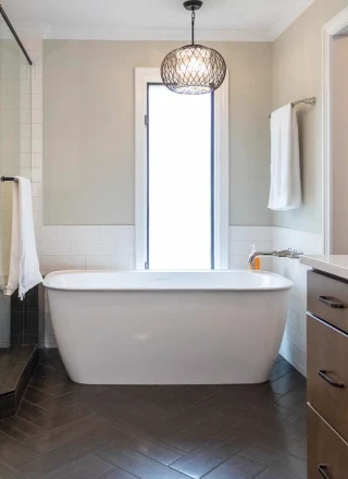 A freestanding tub next to a window