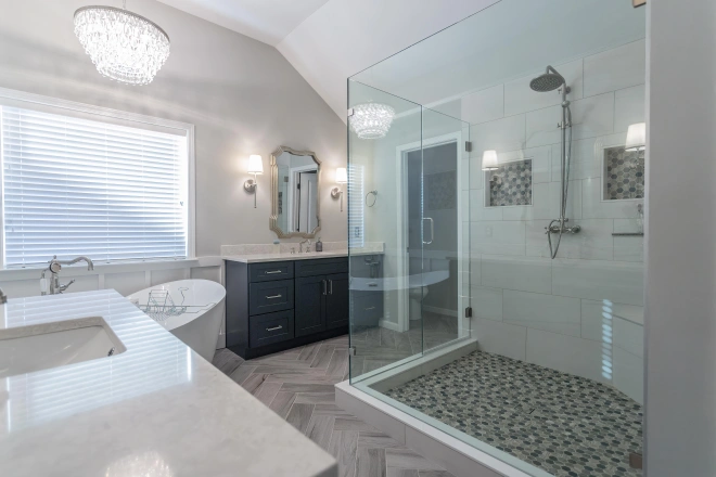 A newly remodeled bathroom with various types of tiles installed on the floor and in the shower
