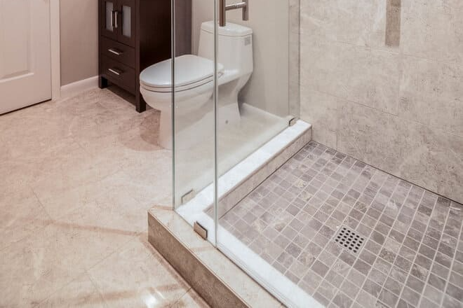 A tiled bathroom floor and a glass enclosed shower visible in the foreground (1)