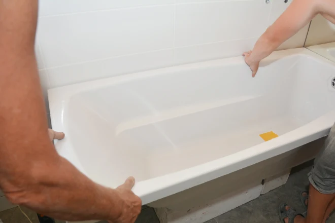 DIYers installing a bathtub