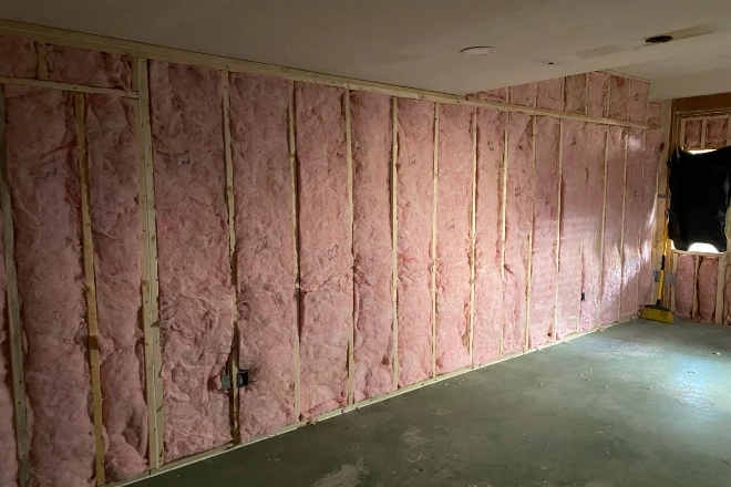 Insulation is visible in the wall of a basement that is being remodeled