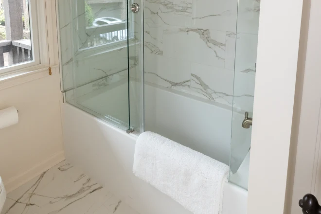 Luxurious marble surrounds this shower-bath combo