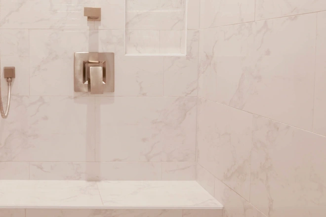 Marble tile covers the interior of a newly remodeled shower